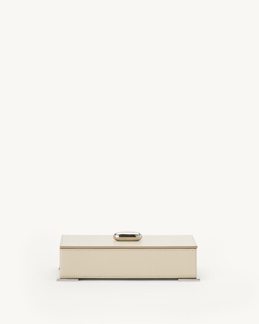 front view of parchment beige leather box with silver hardware on a white background