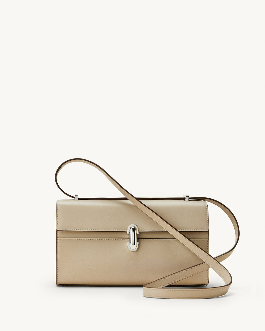 front view of a bone beige leather bag with a silver clasp on a white background