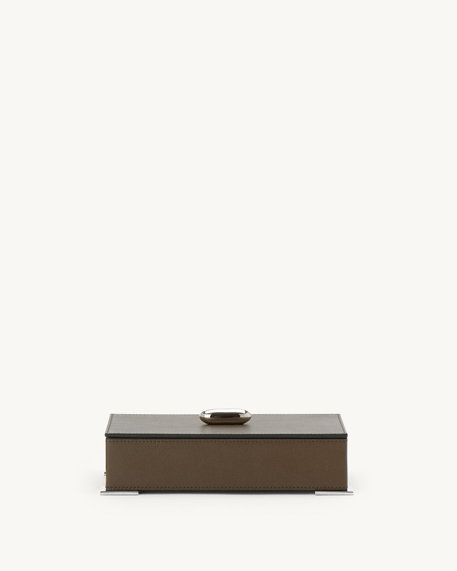 front view of a mink brown leather box with silver hardware on a white background