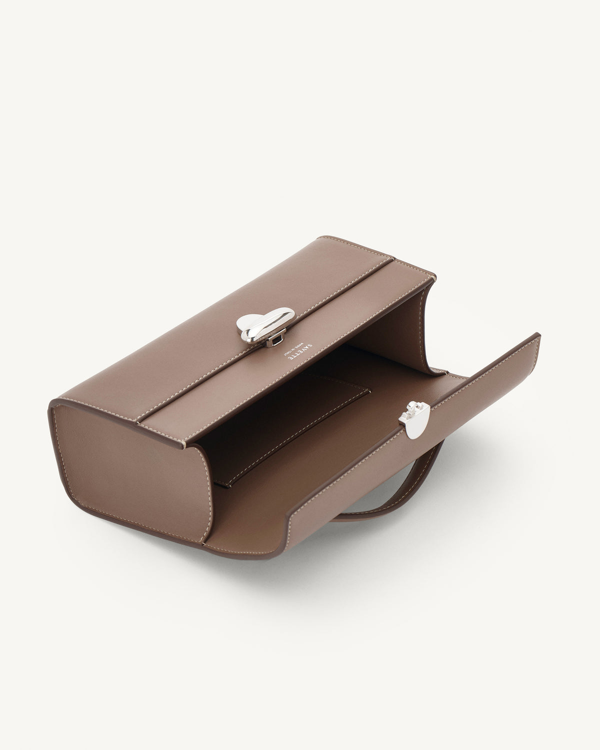 interior view of a taupe brown bag with silver clasp on a white background