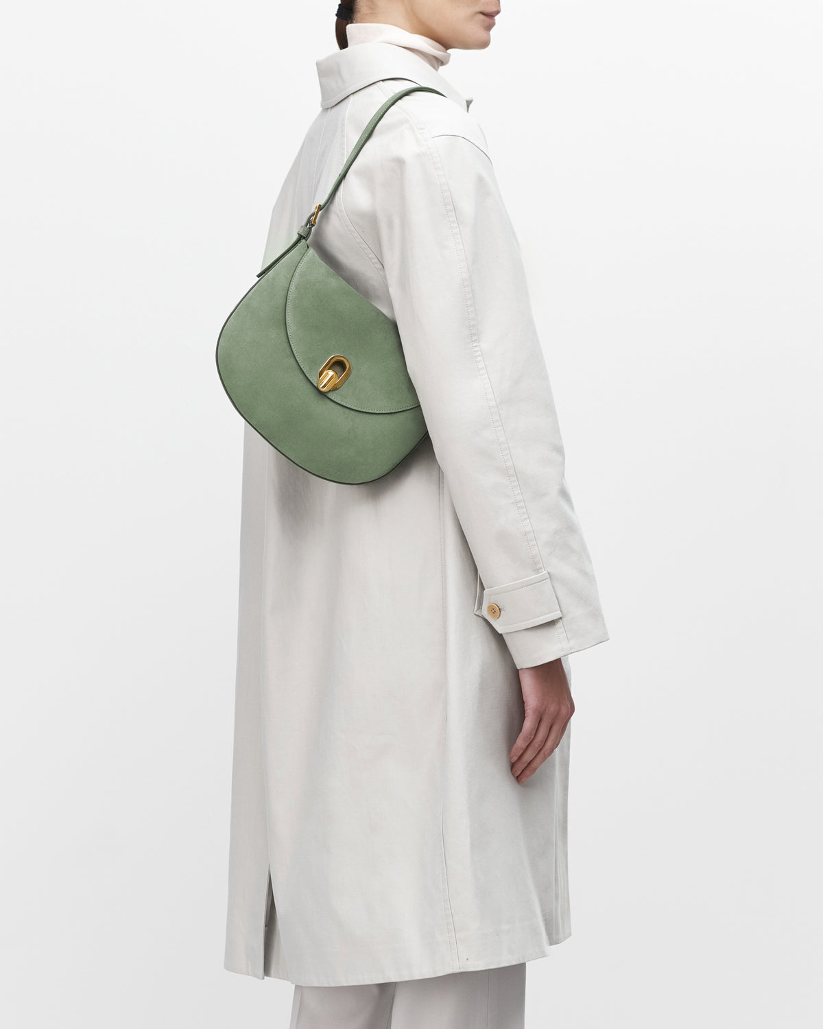 On model view cactus suede handbag with a gold clasp on a white background