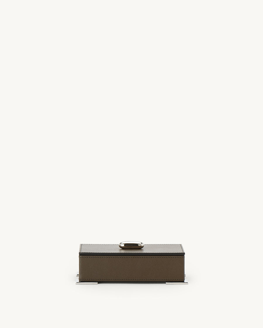 front view of a mink brown leather box with silver hardware on a white background