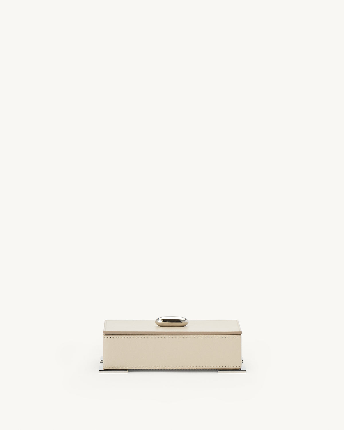front view of a parchment beige leather box with silver metal hardware on a white background