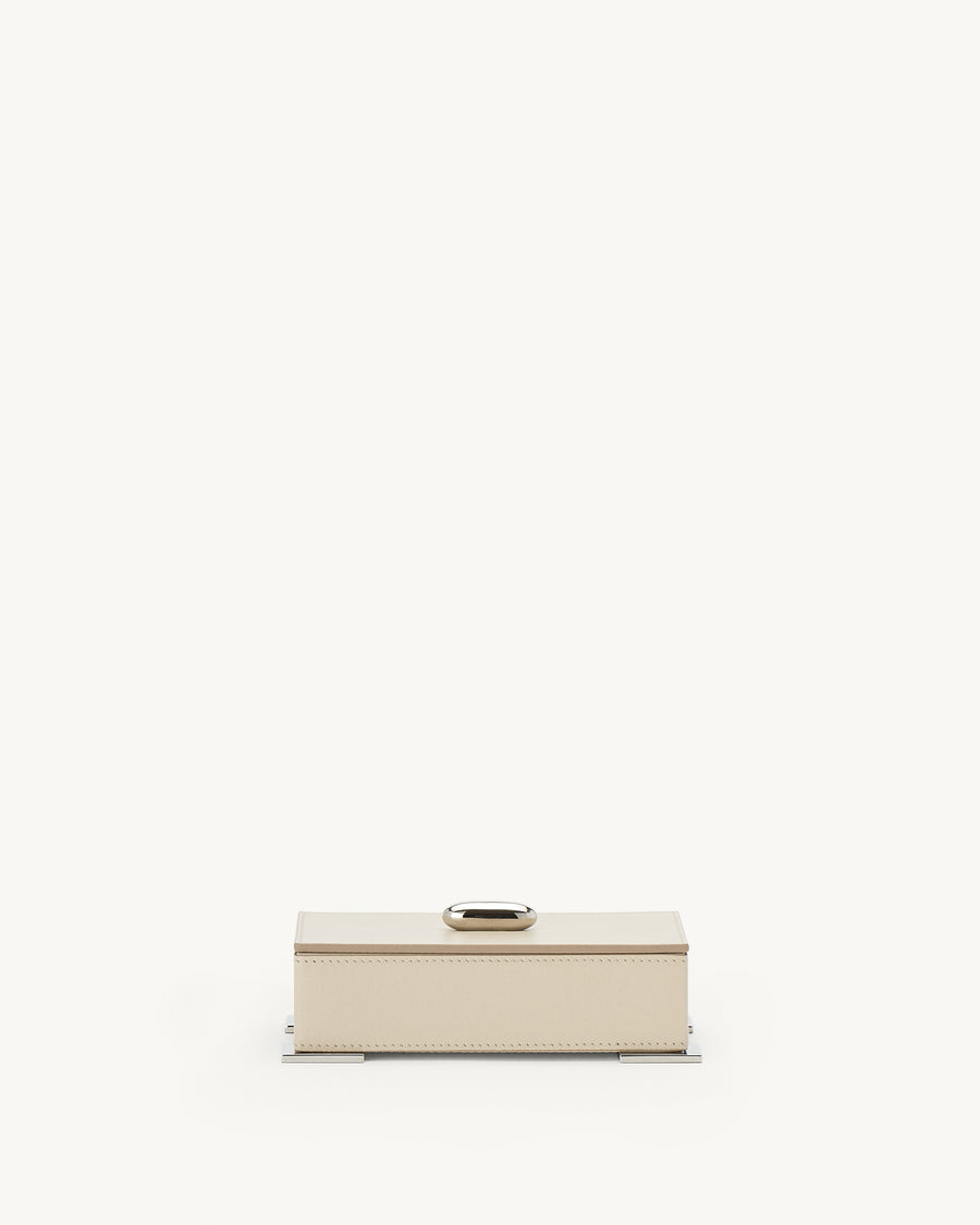 front view of a parchment beige leather box with silver metal hardware on a white background