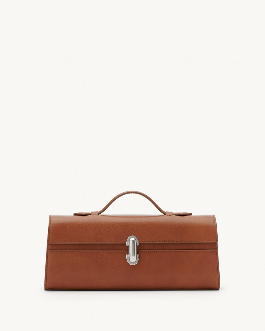 front view of a cognac brown leather top handle bag with a silver clasp on a white background 