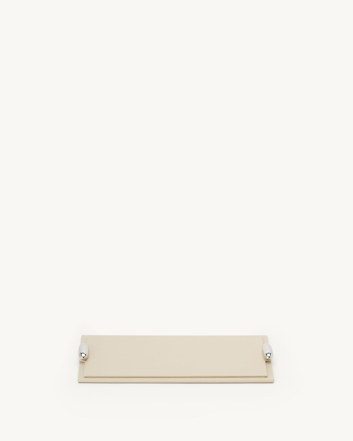 front view of a parchment beige leather tray with silver hardware on a white background