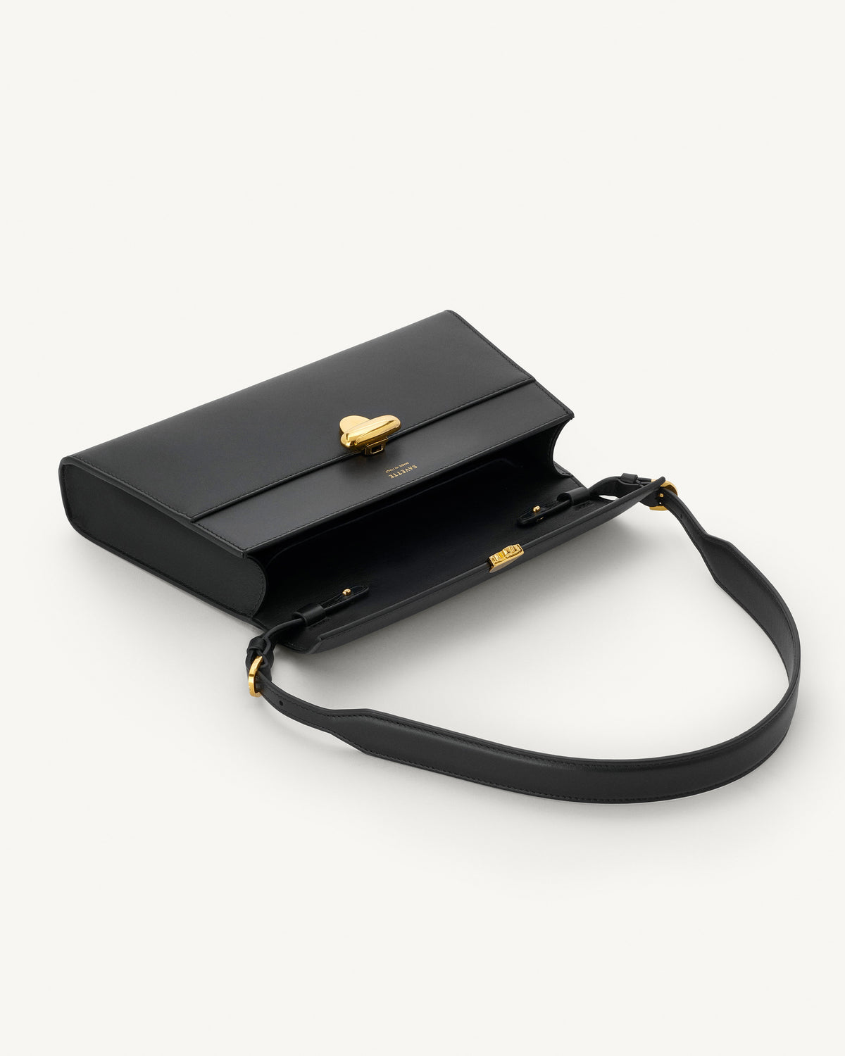 interior view of black bag with gold clasp on a white background