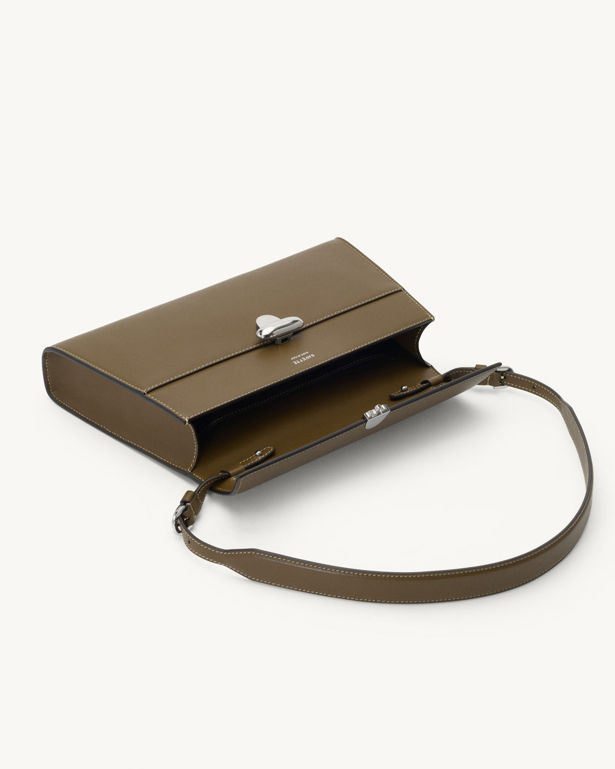 interior view of mink brown bag with silver clasp on a white background