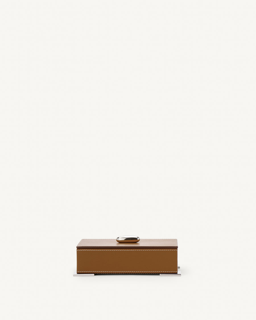 front view of a saddle brown leather box with silver hardware on a white background
