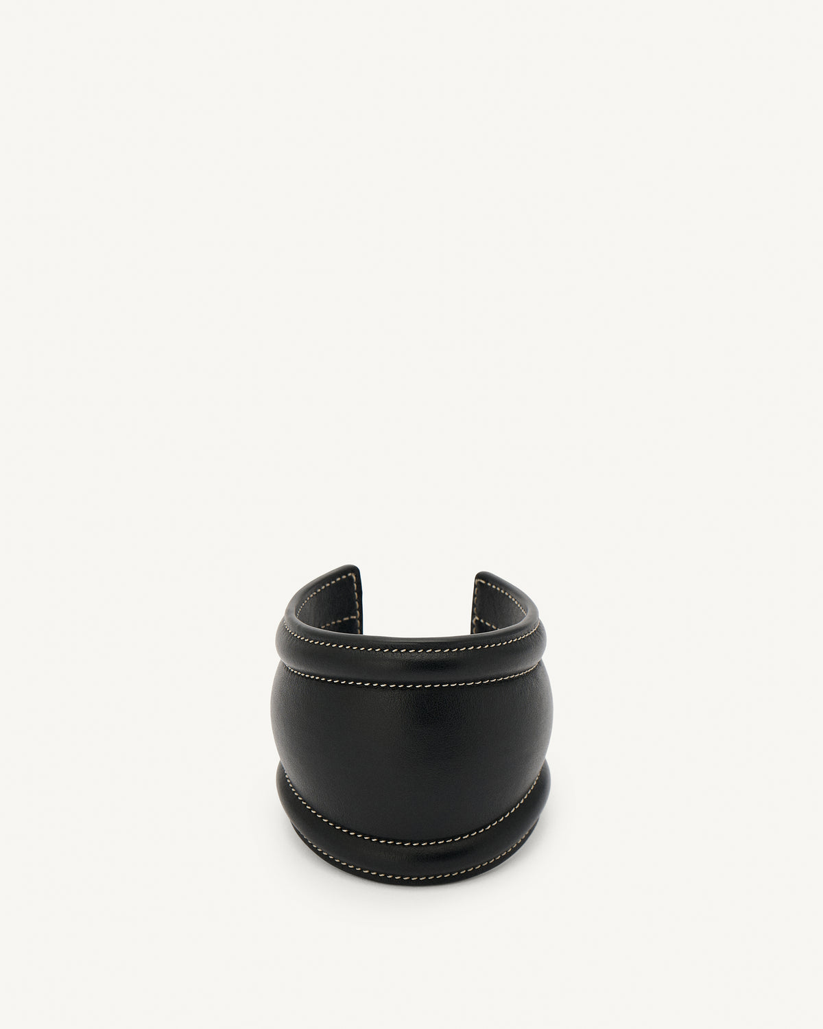 front view of a black leather cuff with white stitching on a white background