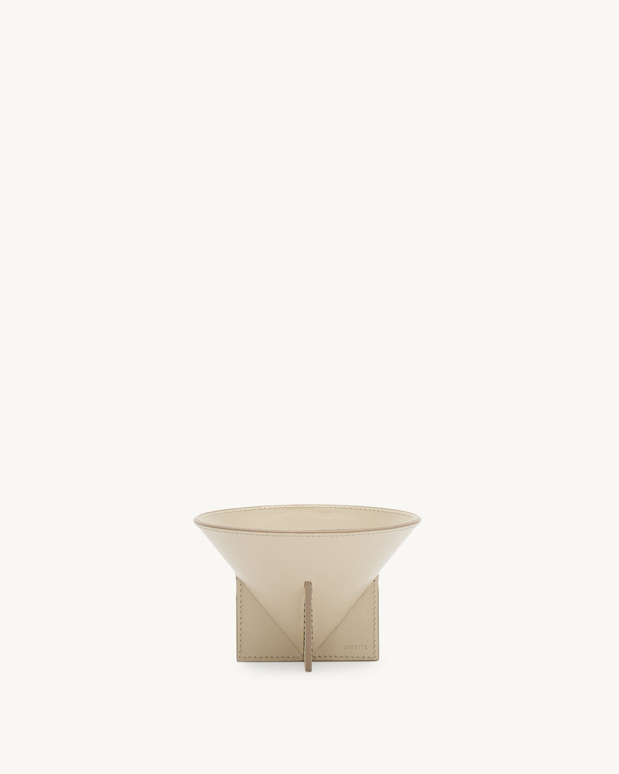 front view of a parchment beige leather dish on a white background
