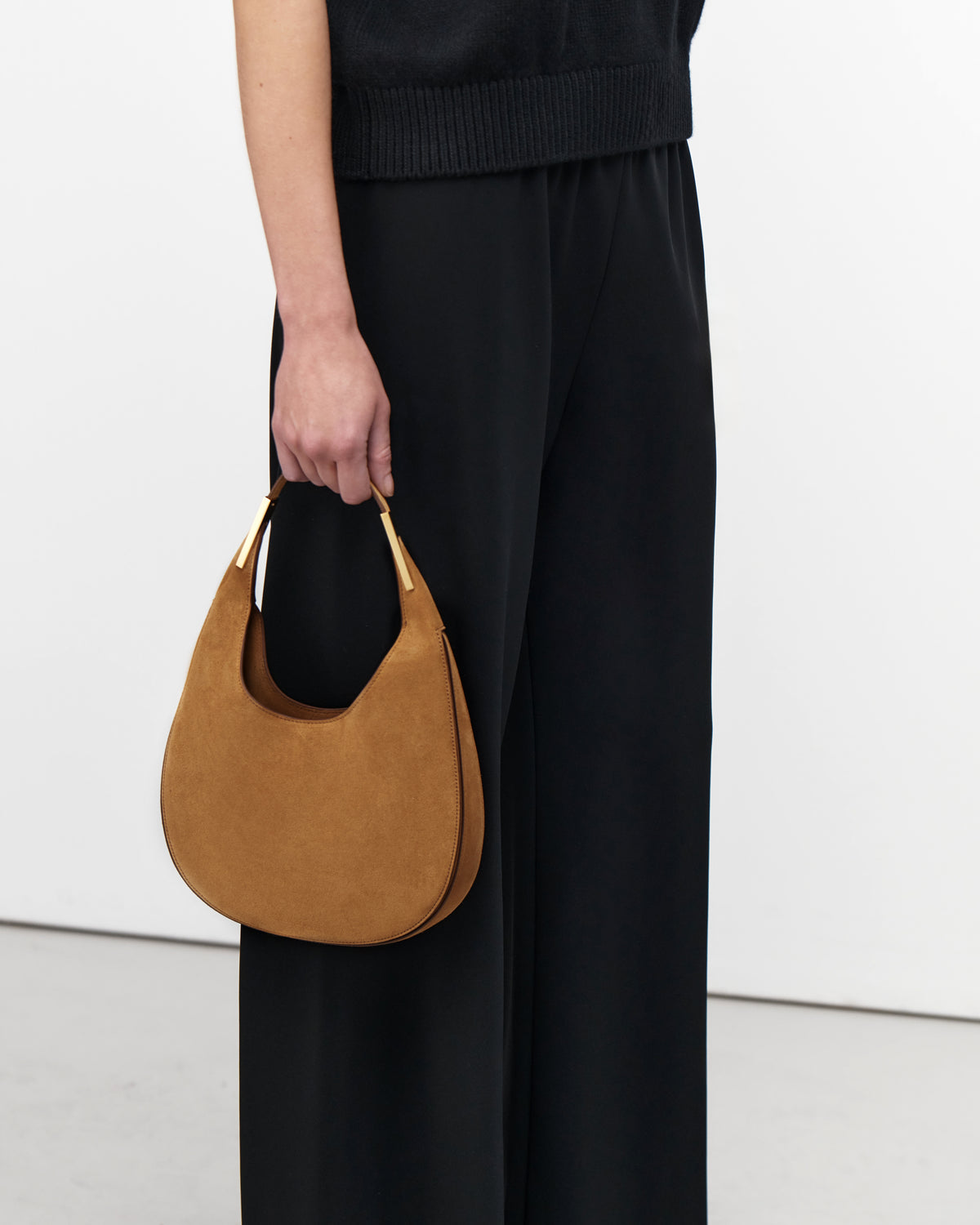 On model view of saddle suede small tote bag with gold hardware on a white background