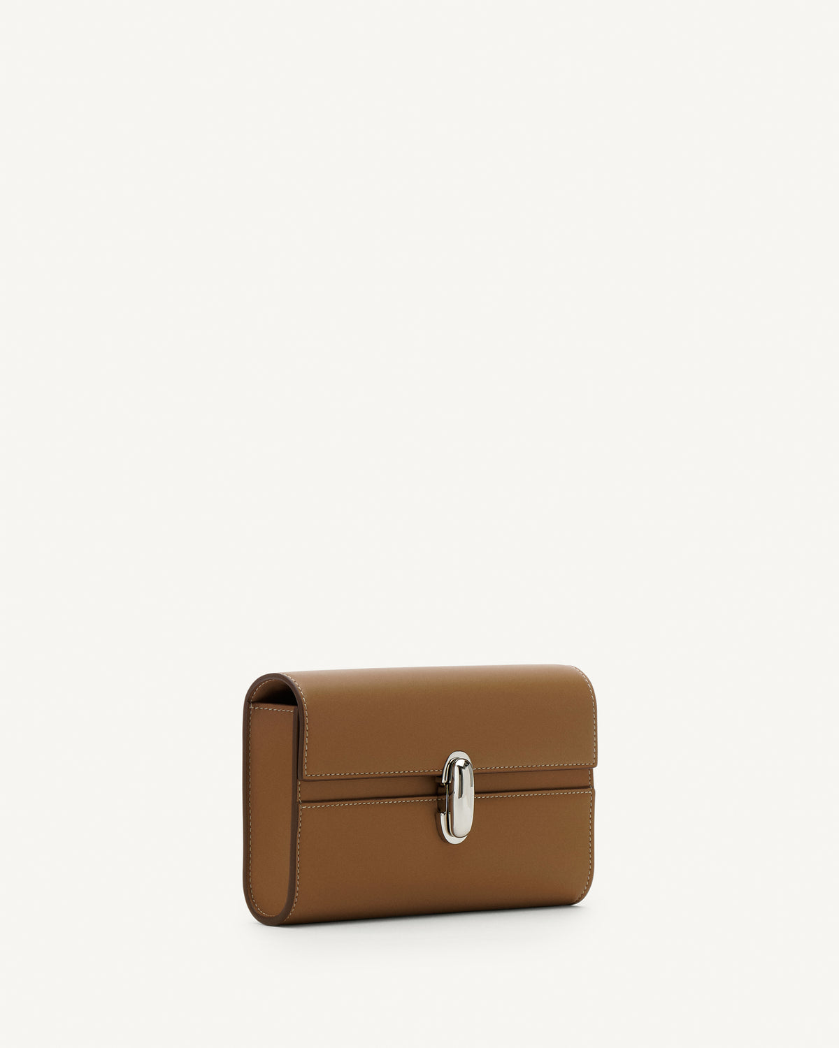 Side view of saddle leather handbag with silver hardware and a crossbody strap on a white background