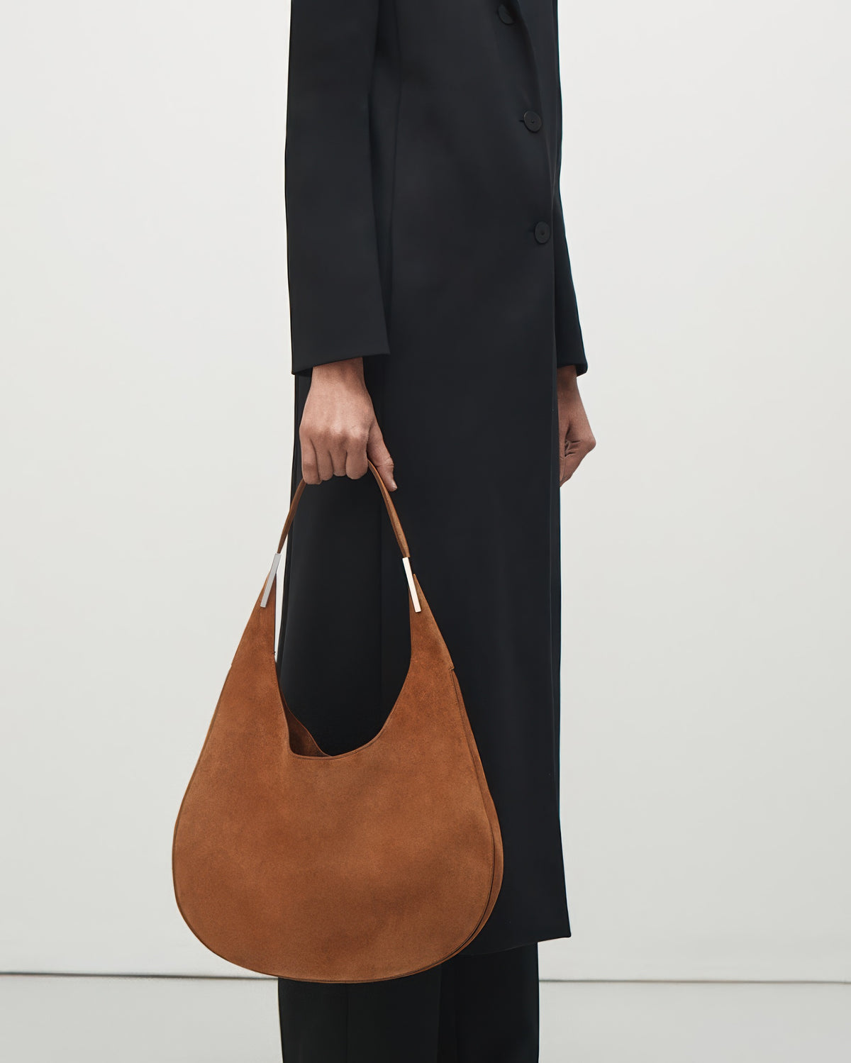 interior view of a cognac brown suede shoulder bag with silver hardware 