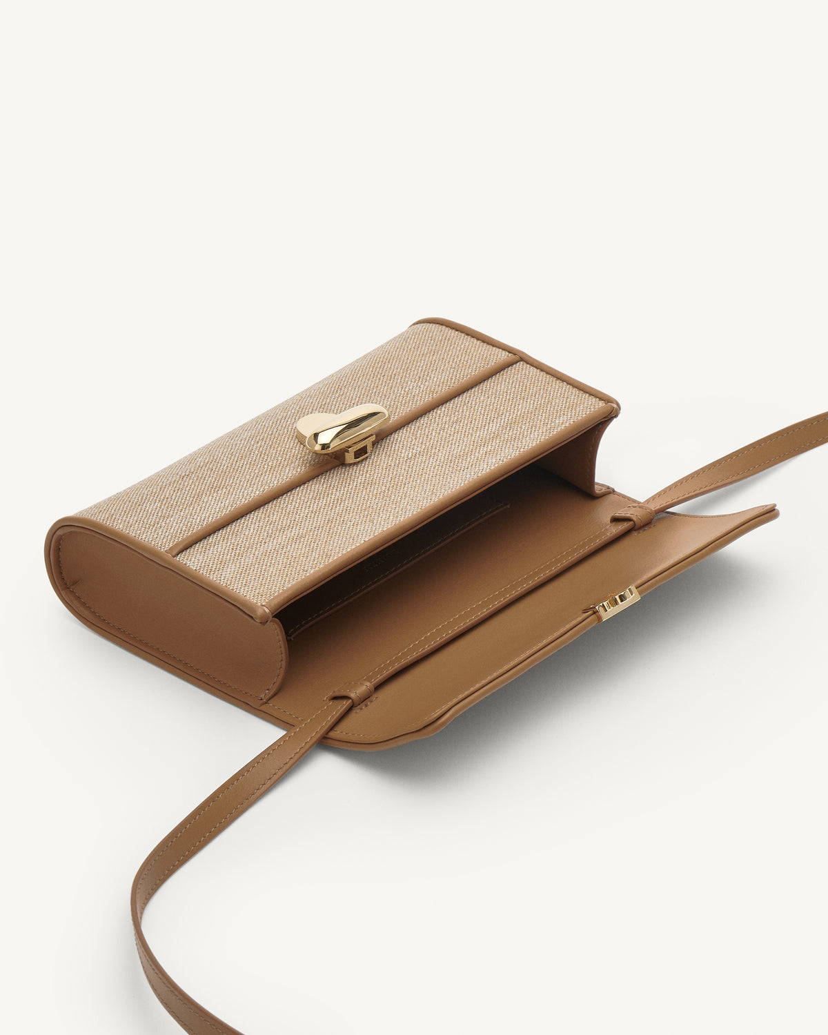 Inside view of beige handbag with a brown strap and gold hardware on a white background