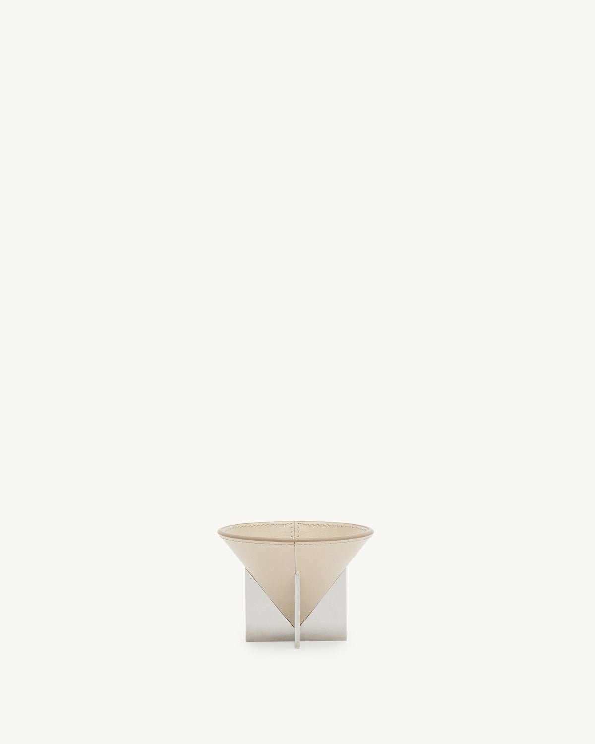 front view of a parchment beige leather dish with silver metal feet on a white background