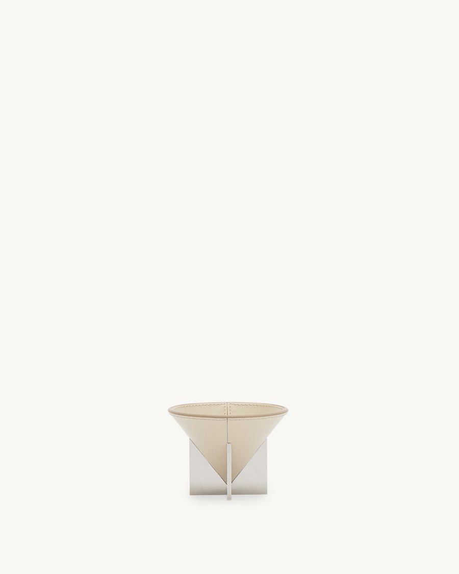 front view of a parchment beige leather dish with silver metal feet on a white background