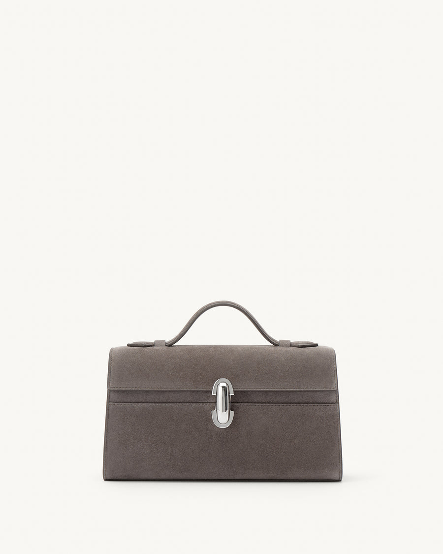 front view of a smoke grey suede top handle bag with a silver clasp on a white background