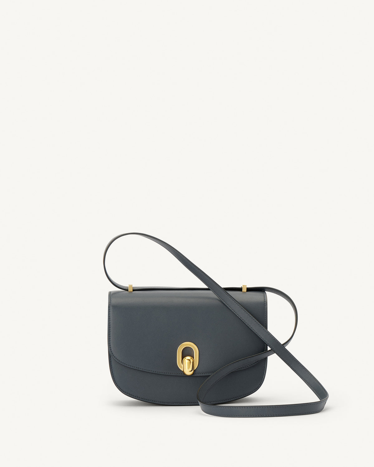 front view of a storm blue leather bag with gold hardware on a white background