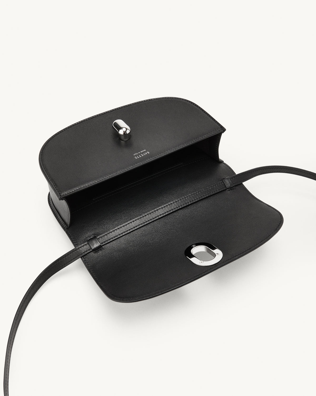 inside view of a black bag with a silver clasp on a white background