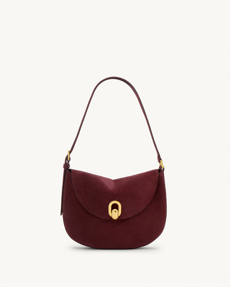 front view of a plum red suede bag with gold hardware on a white background