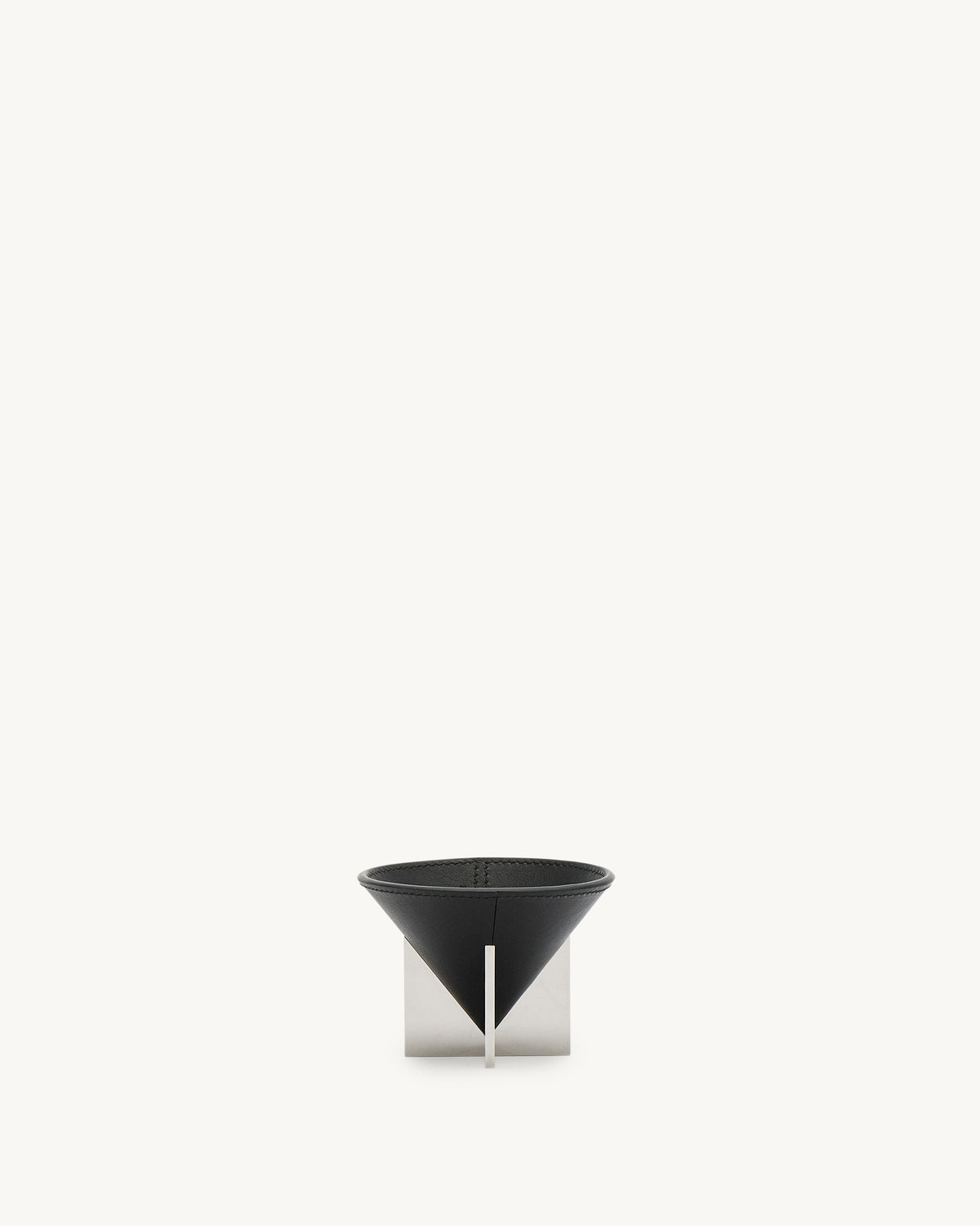 front view of a small ebony black leather dish with silver metal feet on a white background