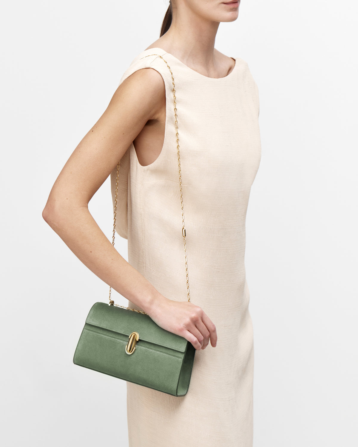 On model view of cactus suede handbag with a gold chain on a white background