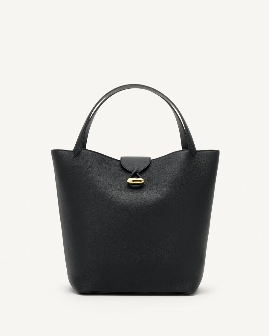 front view of a black tote bag with gold hardware on a white background