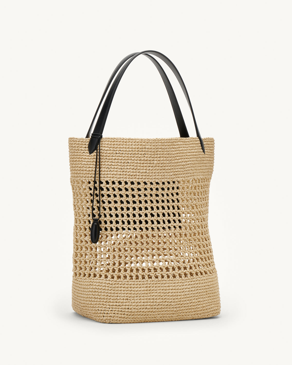 Side view raffia tote bag with black handle on a white background
