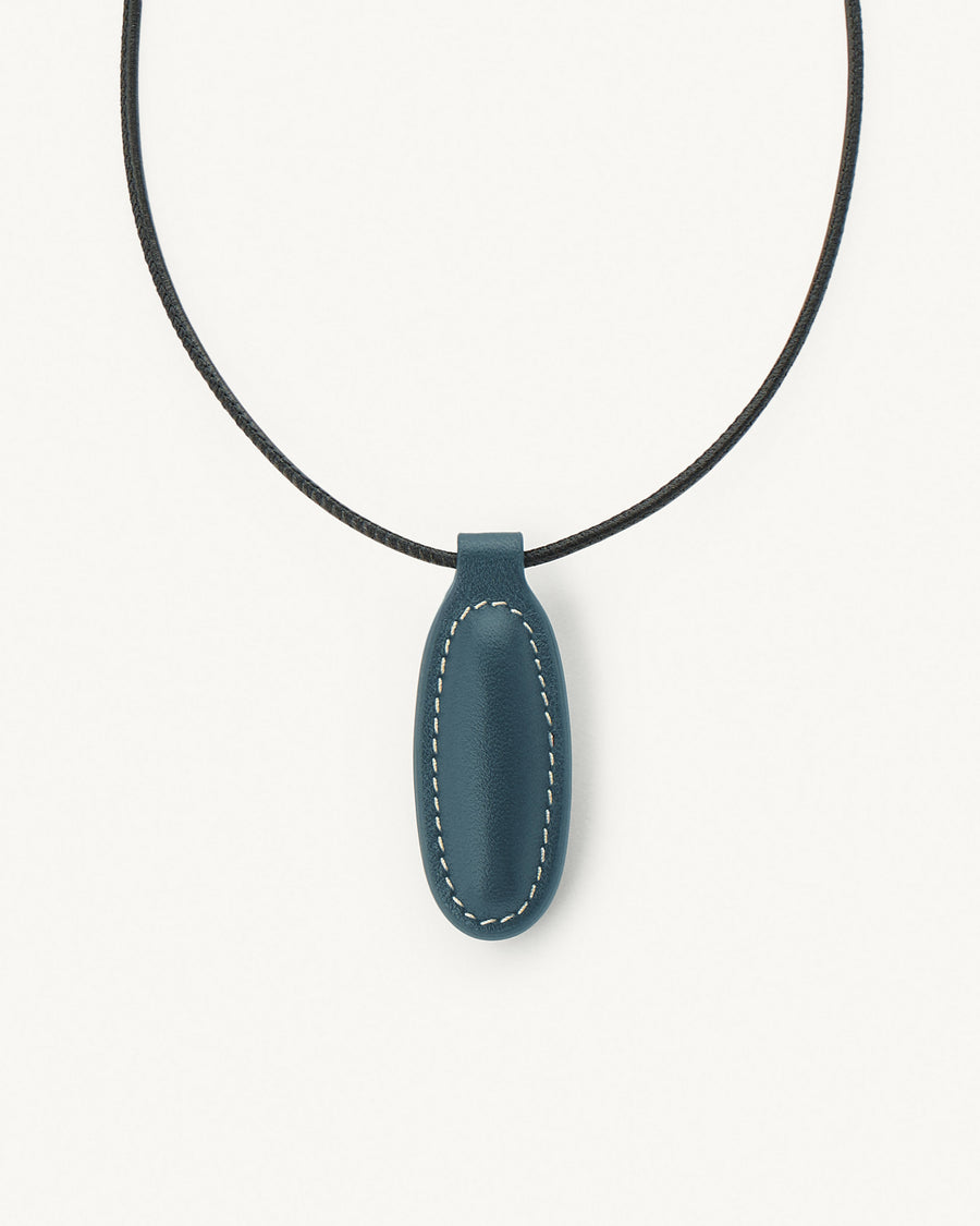 front view of ocean blue leather pendant on a white background
