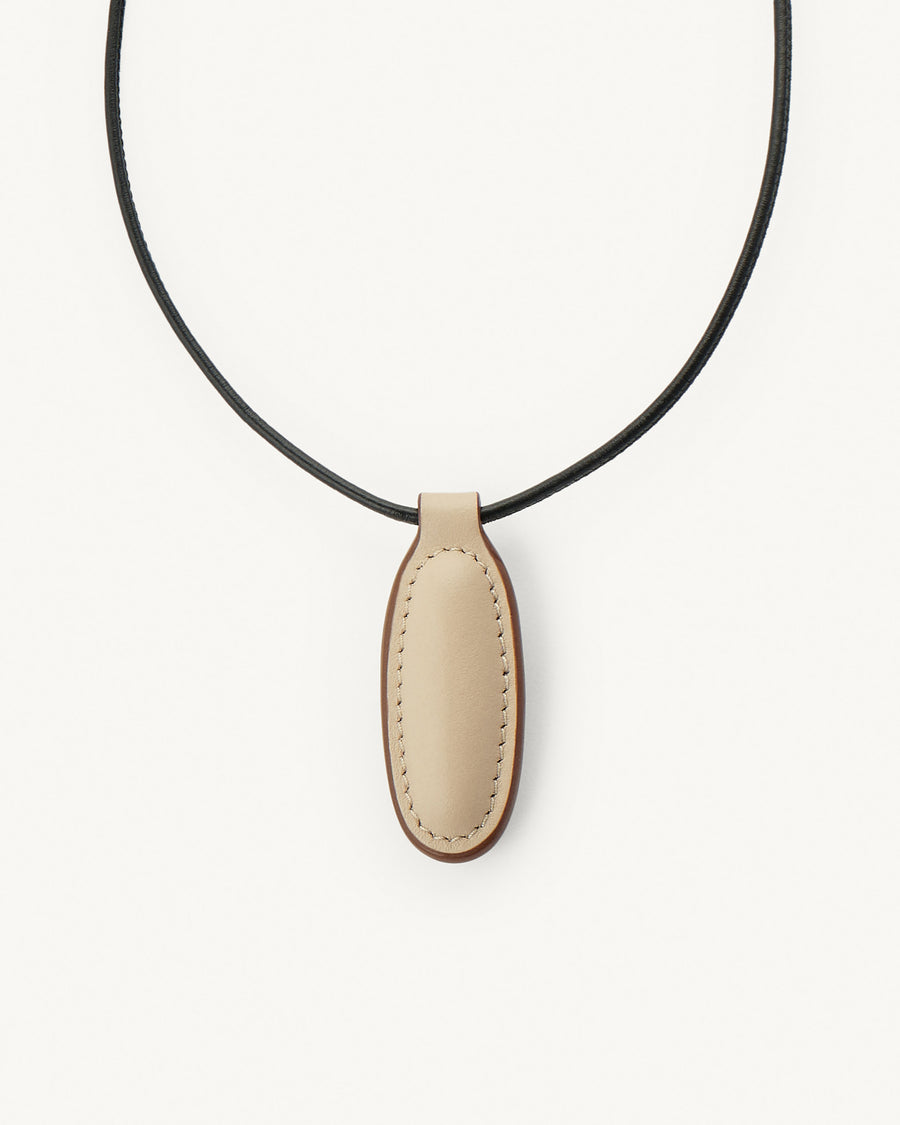 Necklace with a beige leather pendant on a white background