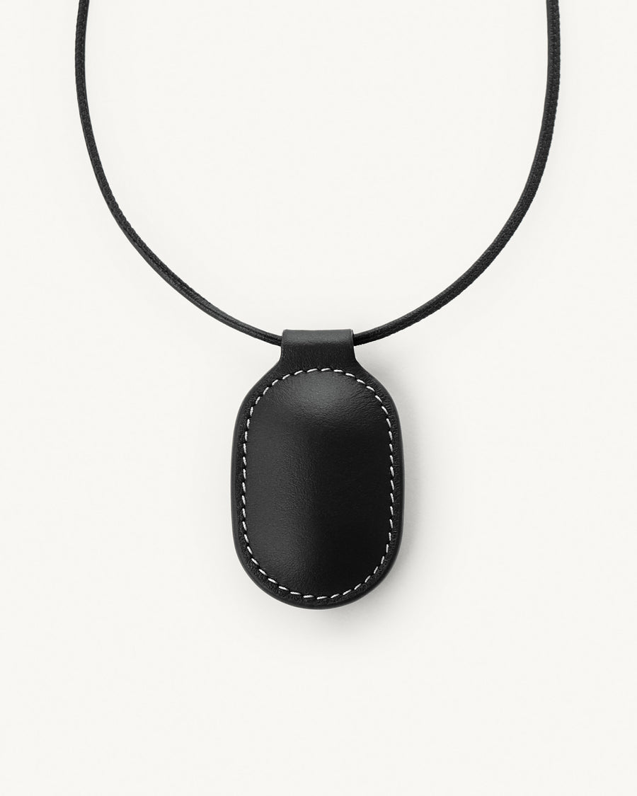 front view of black leather pendant on a white background