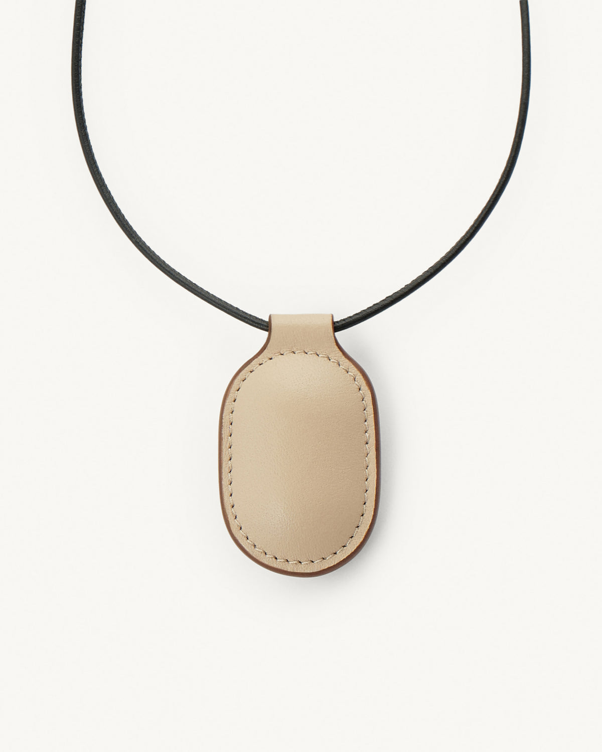 front view of bone beige leather pendant on a white background