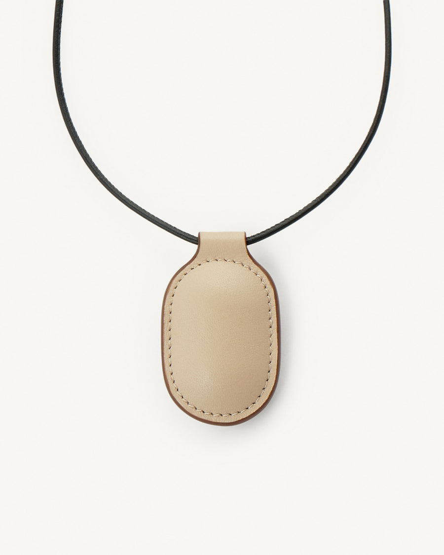 front view of bone beige leather pendant on a white background