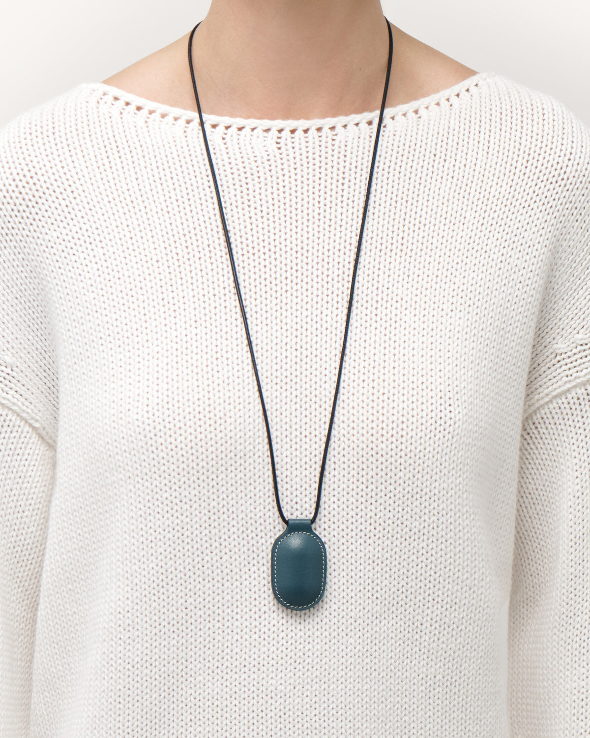 on model view of ocean blue leather pendant on a white background
