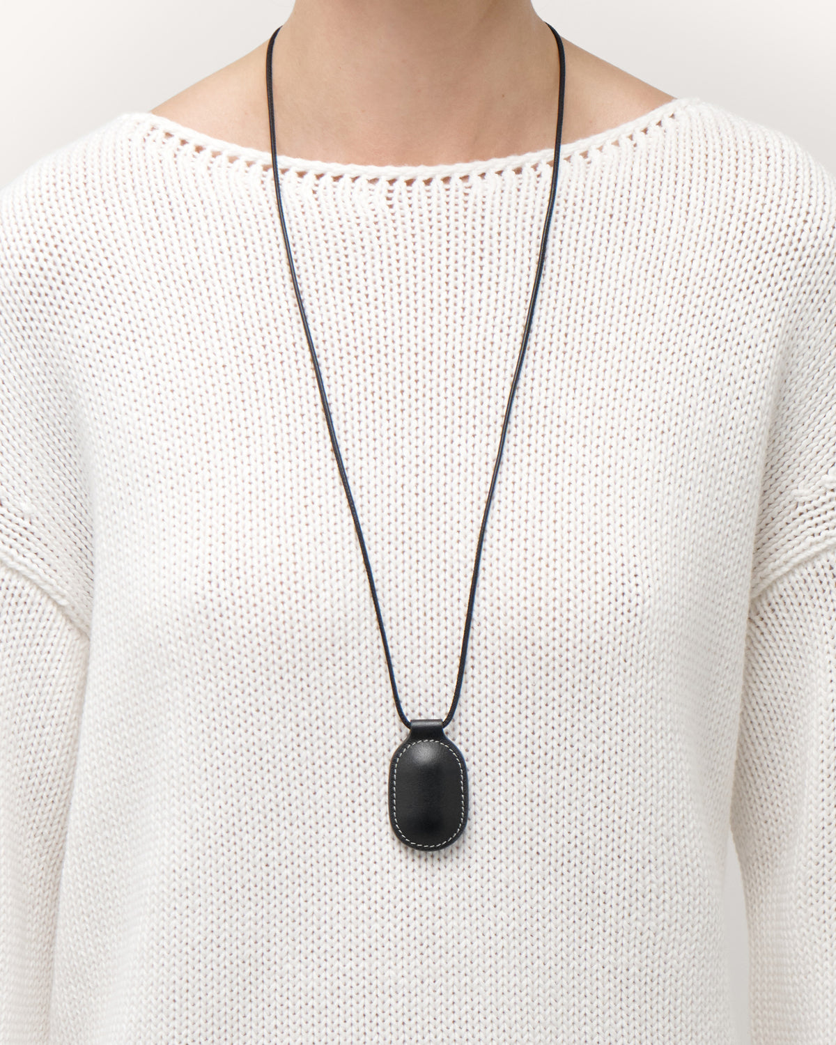on model view of black leather pendant on a white background