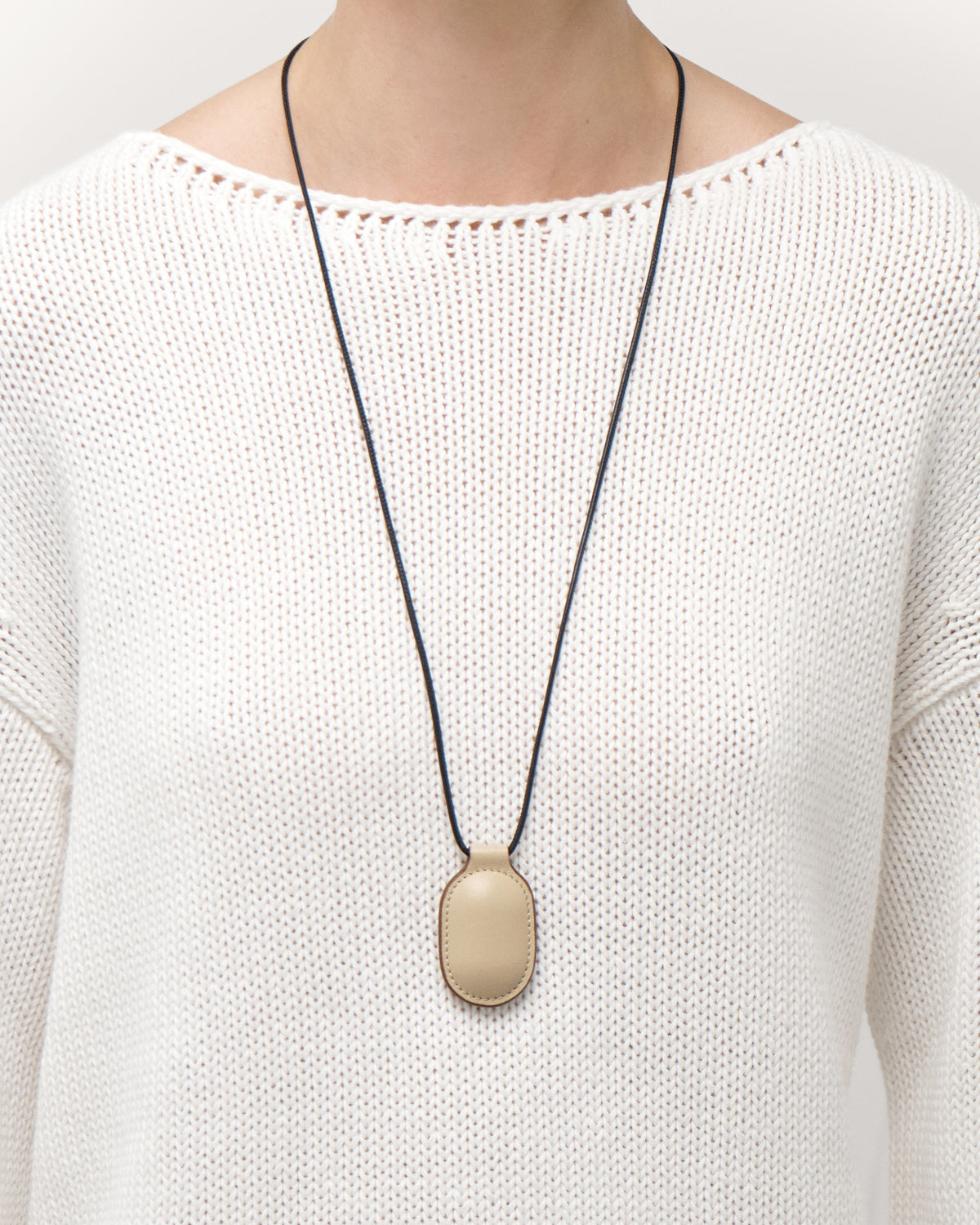 on model view of bone beige leather pendant on a white background