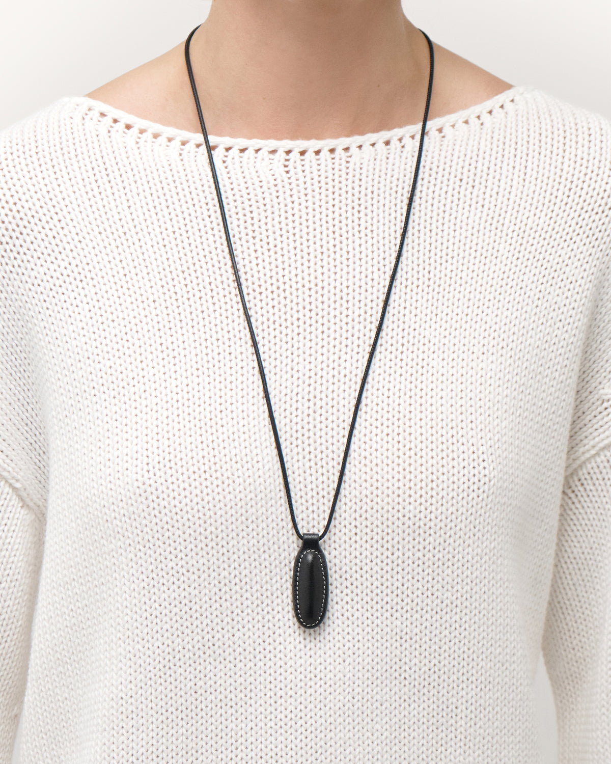on model view of black leather pendant on a white background