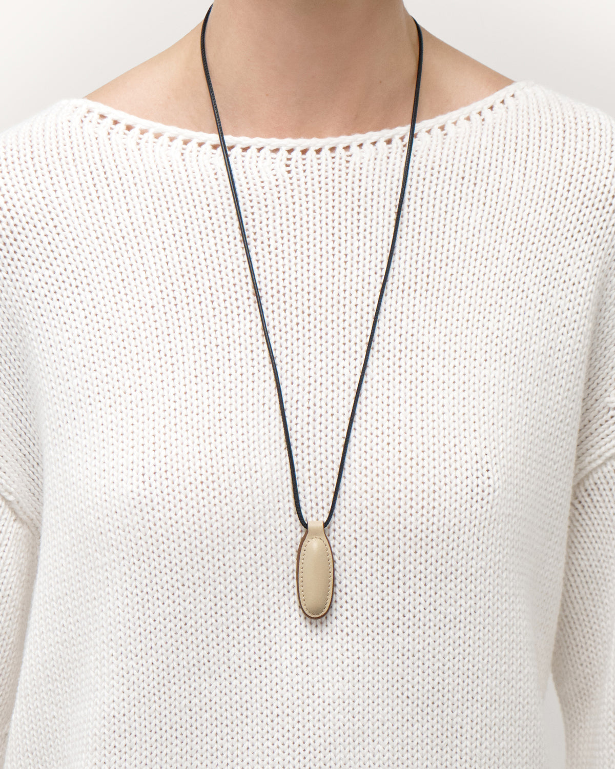 on model view of bone beige leather pendant on a white background
