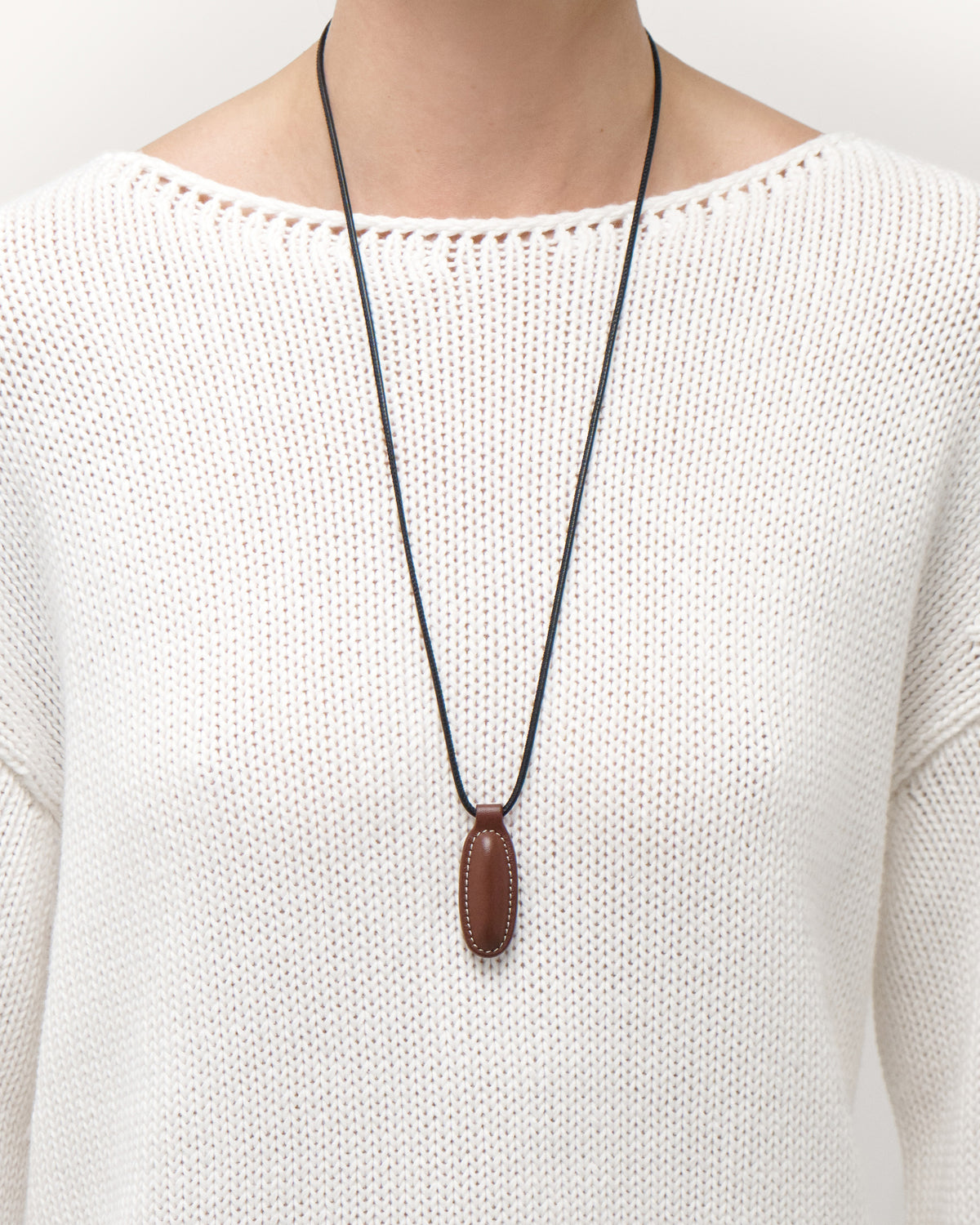 on model view of espresso brown leather pendant on a white background