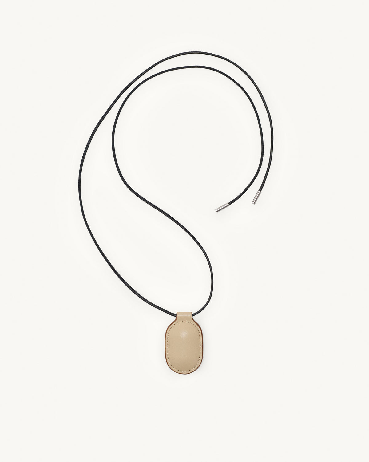 top view of bone beige leather pendant on a white background