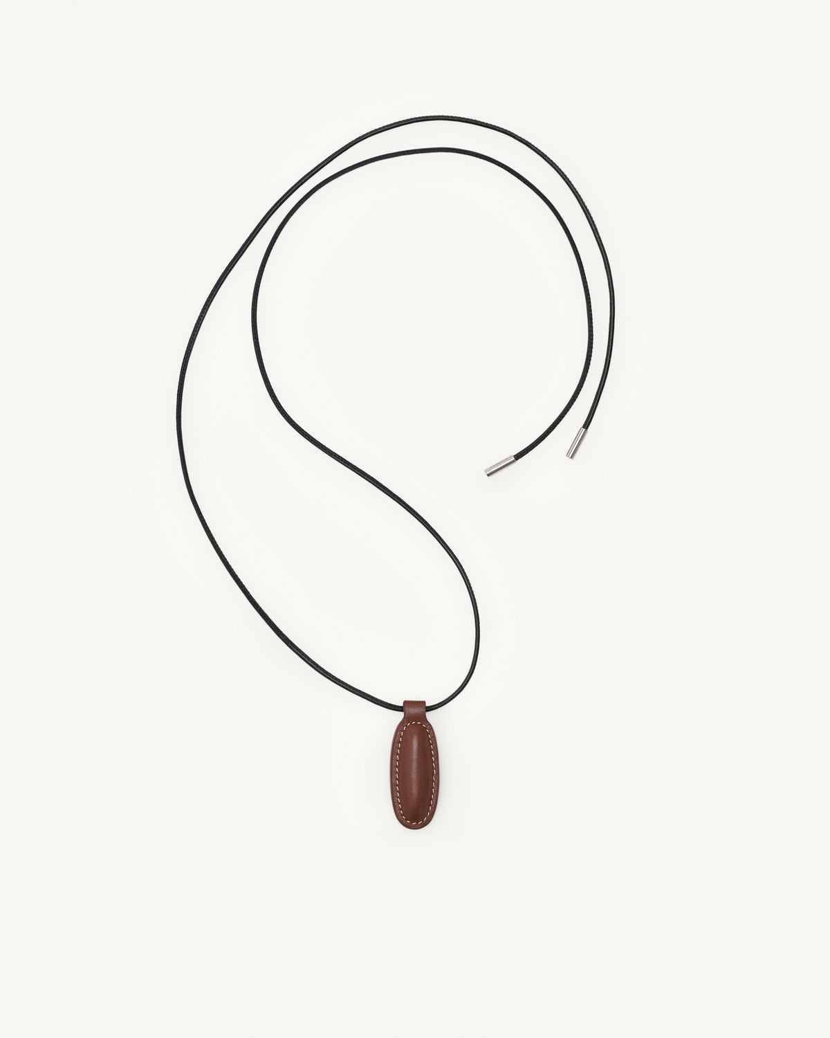 top view of espresso brown leather pendant on a white background