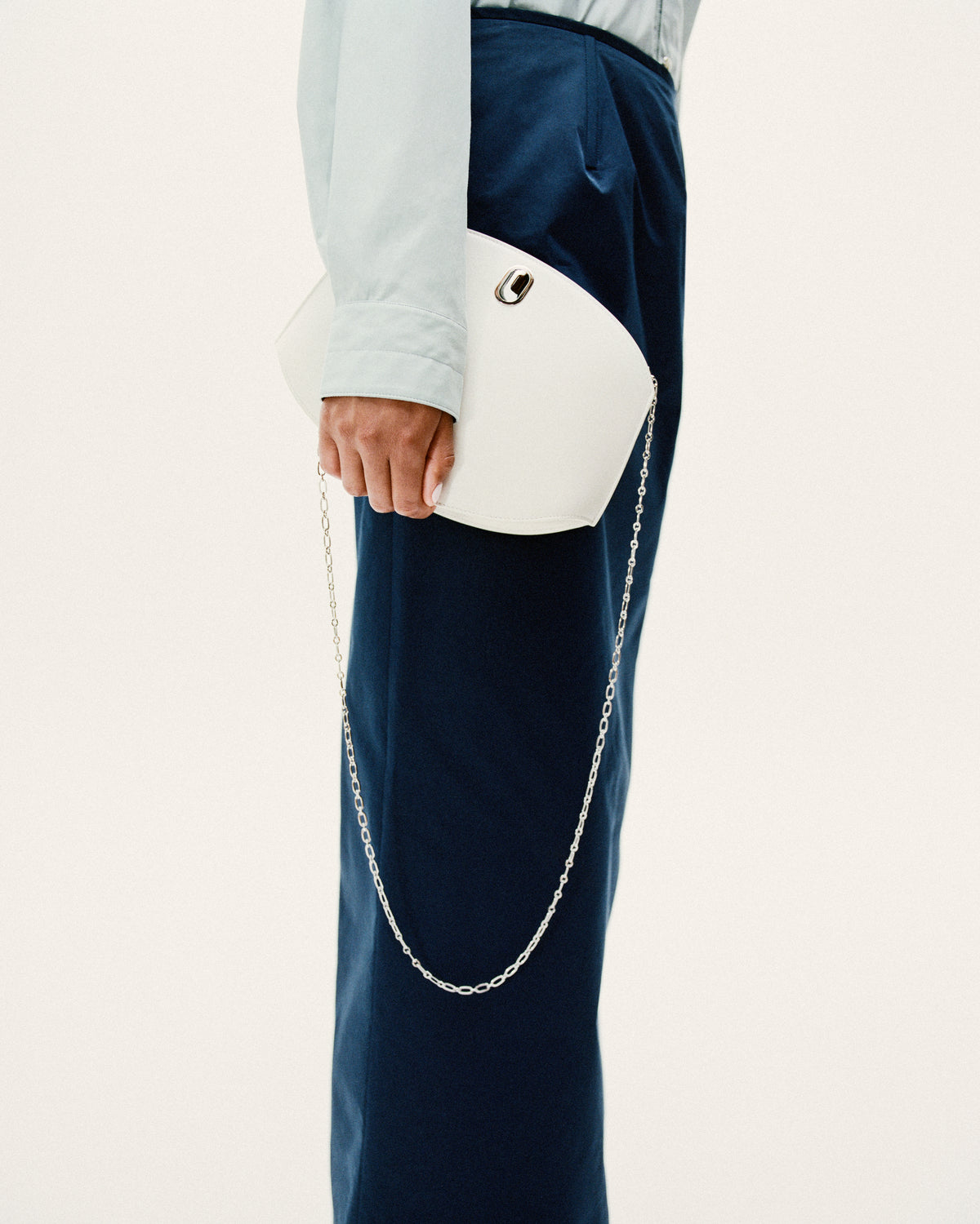 on model image of a ivory white bag with silver hardware and silver chain on a white background