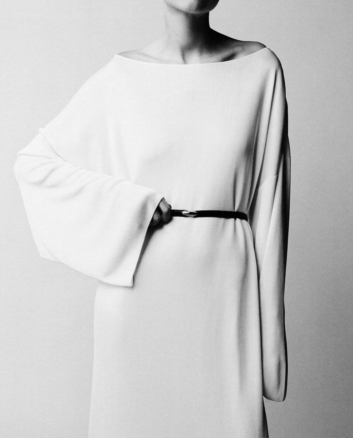 black and white on model image of a black belt with gold clasp