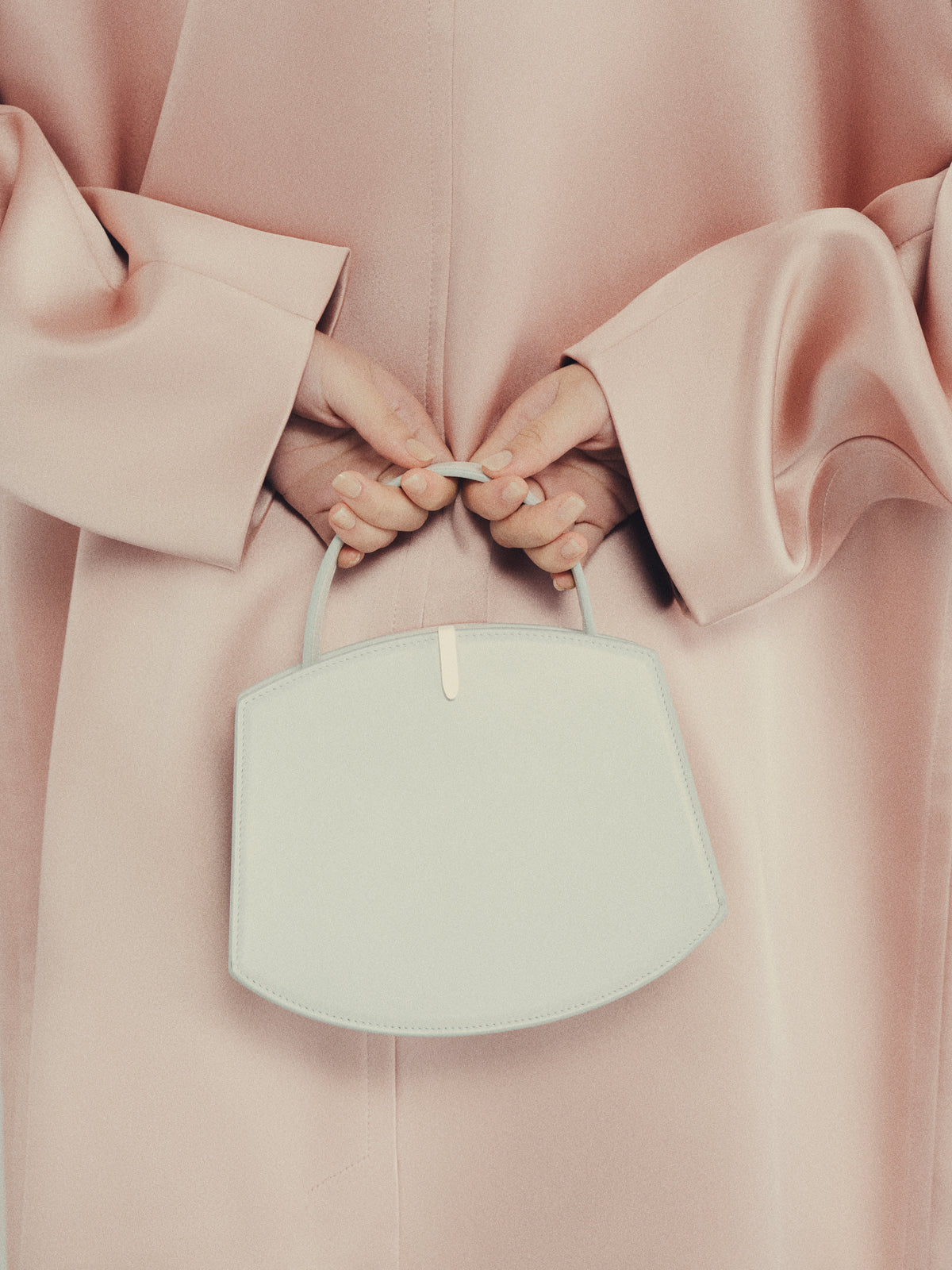 Woman in pink coat carrying white Florence 20 handbag