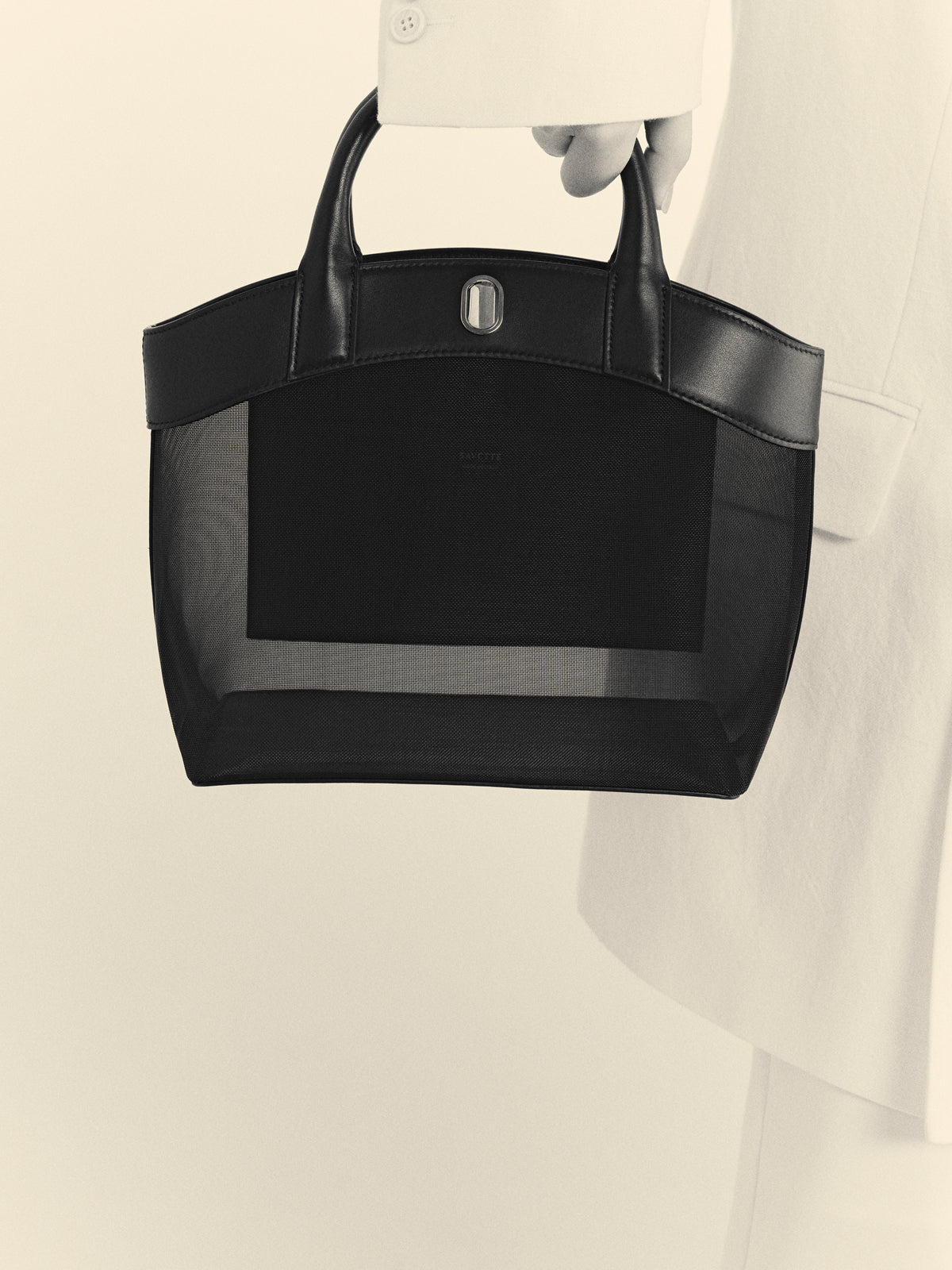 black and white image of a black mesh bag with black trim with silver hardware on a white background