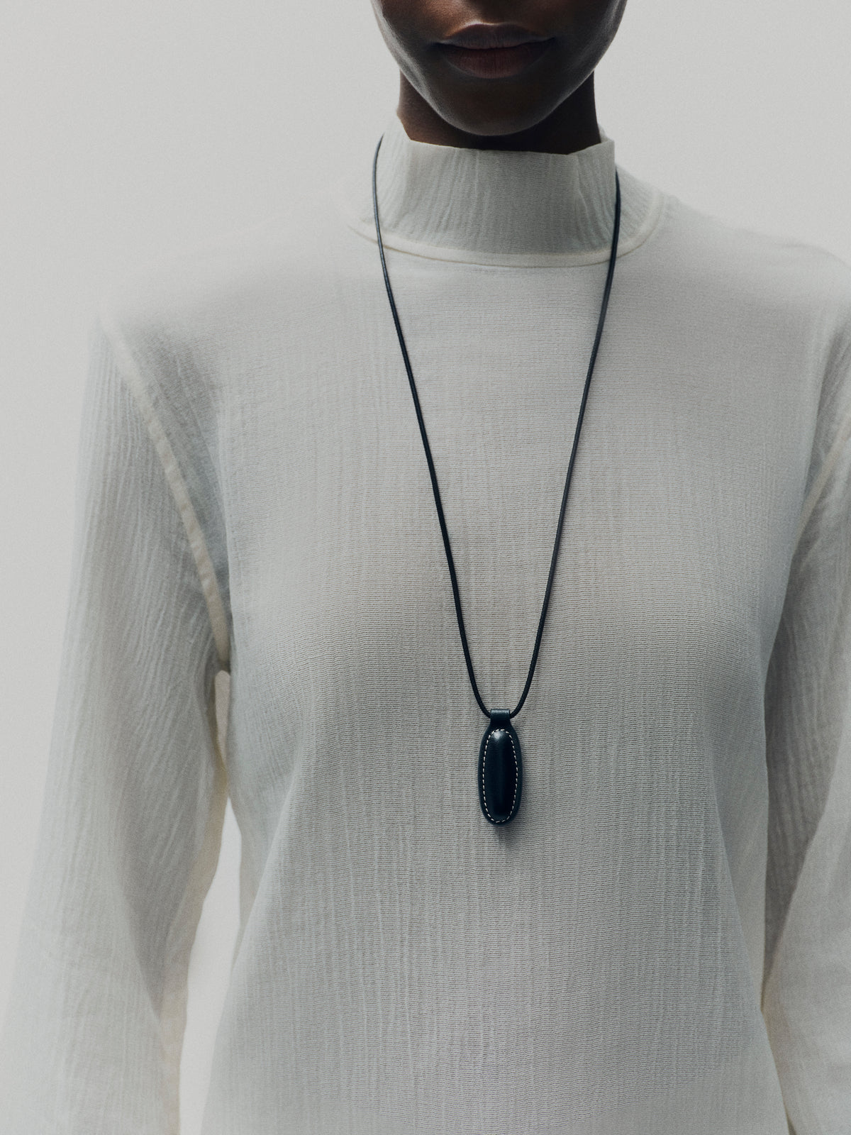 on model image of black leather pendant on a white background