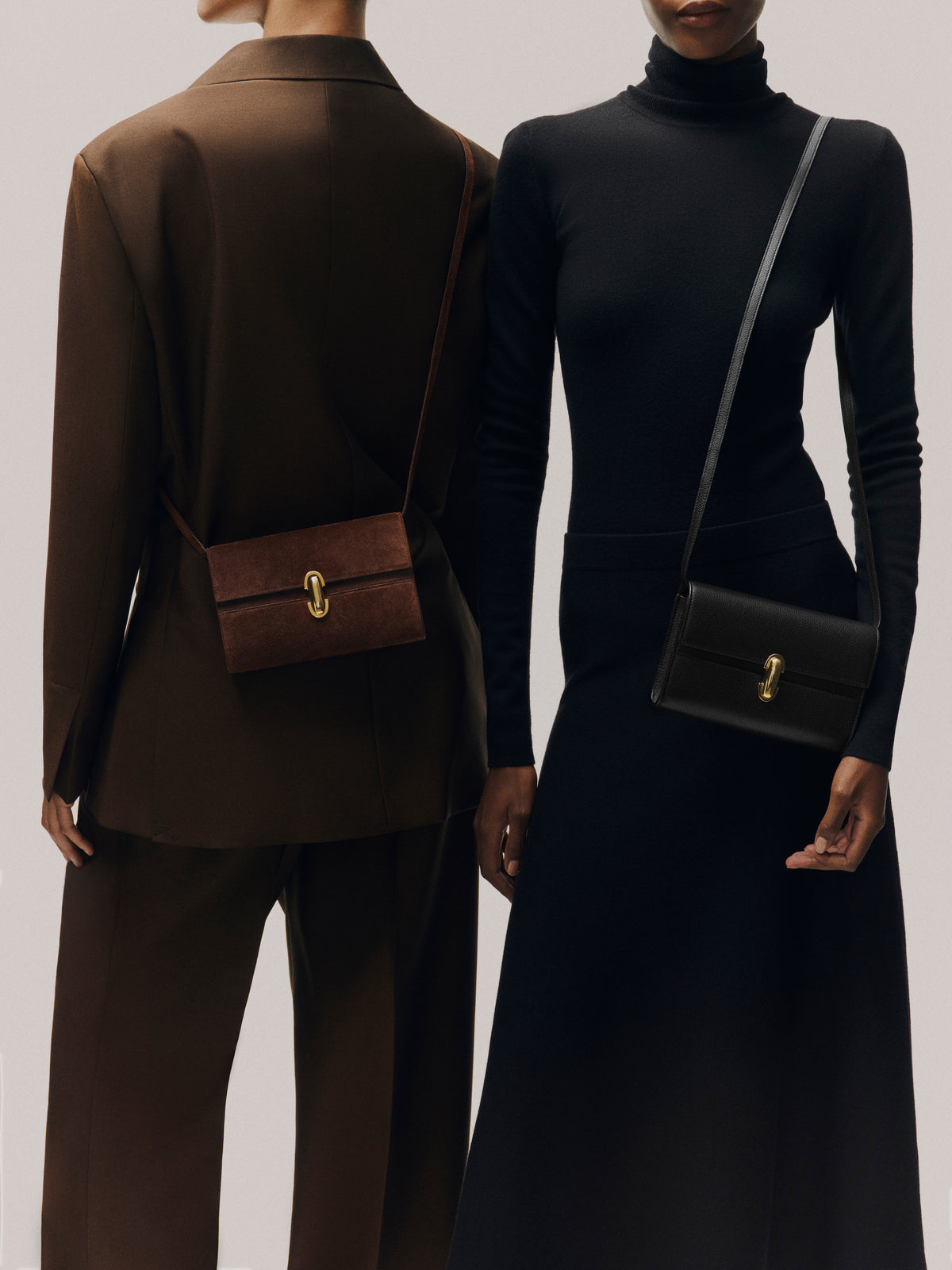 campaign on model image of two models with an espresso brown suede bag with gold clasp and black bag with gold clasp on a white background