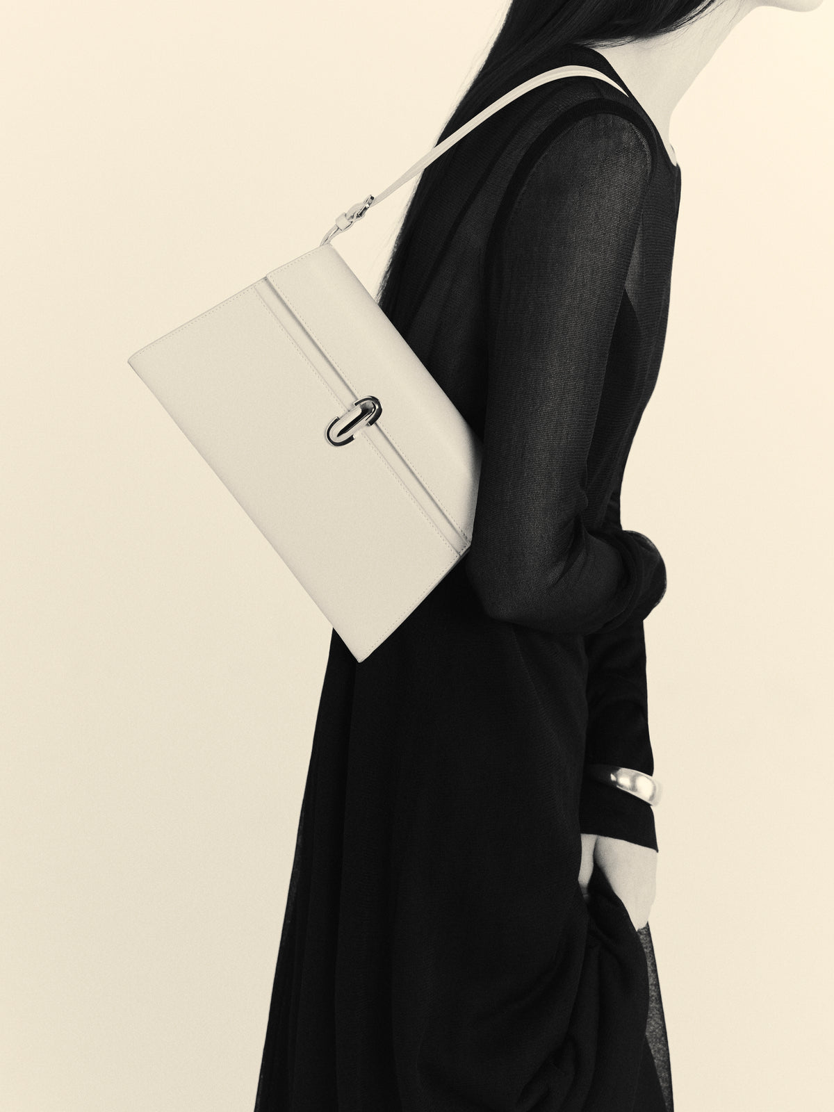Side view of woman carrying white Symmetry Shoulder bag handbag