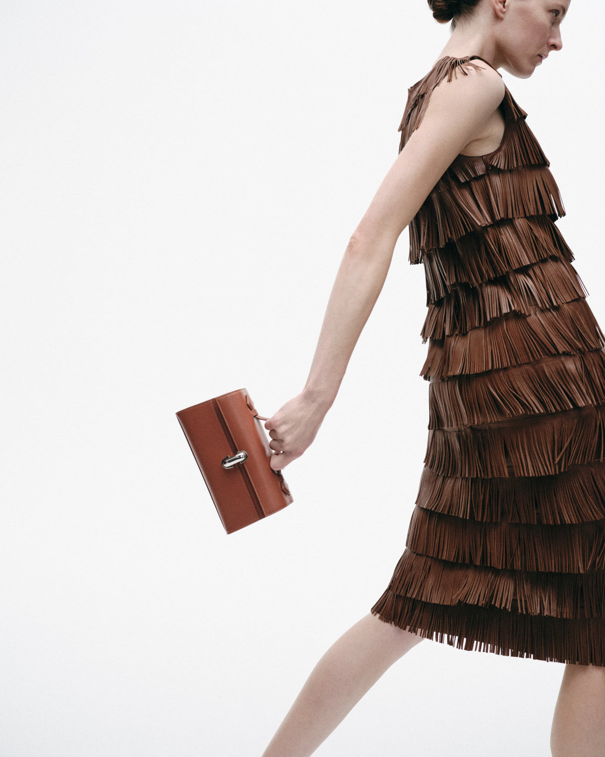 on model image of a brown bag with a silver clasp on a white background